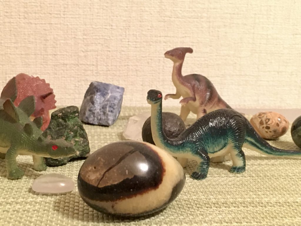 恐竜のフィギュアと天然石の画像