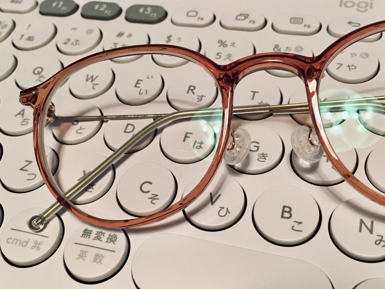 キーボードの上に置いたメガネの画像