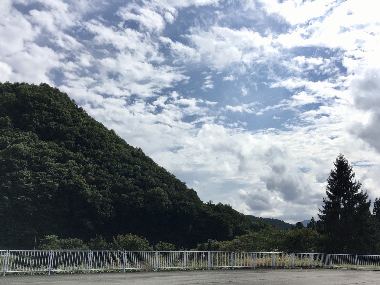 駐車場から見た、山と青空の画像